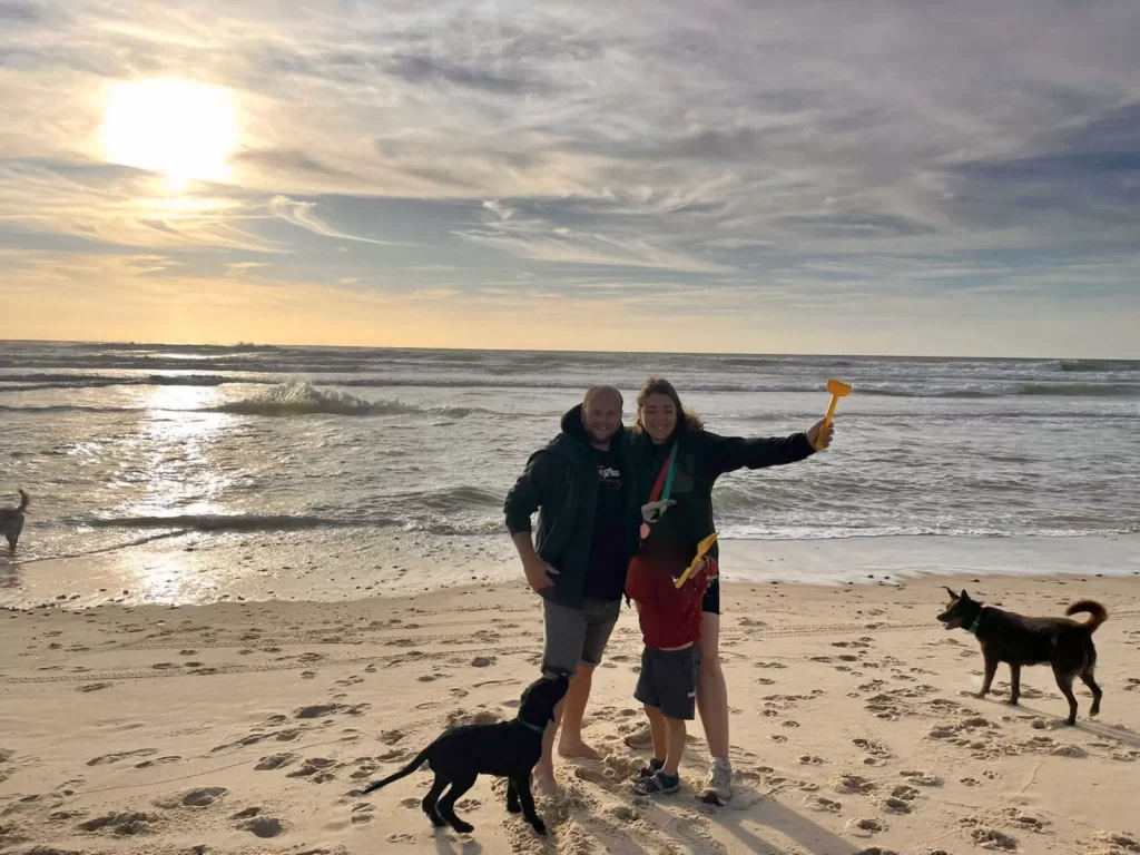 Famille et trois chiens sur une plage de Lacanau au coucher du soleil